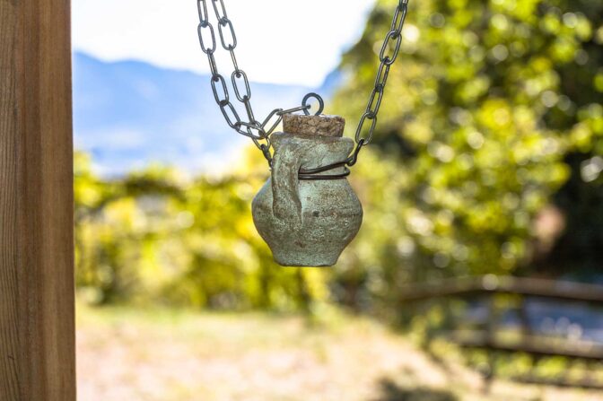 Amphoren mit den Gerüchen des Weins hängen am Wegesrand des Weinlehrpfad Kurtatsch im Südtirol Süden