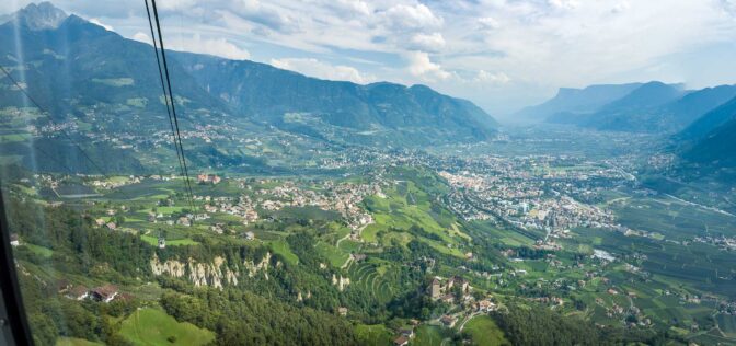 Blick aus dem Inneren der Kabine der Hochmuthbahn nach Dorf Tirol und Meran. Auch im Bild: Die Erdpyramiden in Dorf Tirol und Kuens.