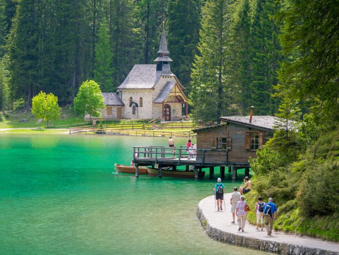 Touristen und Spaziergänger am Pragser Wildsee. Im Hintergrund die Kapelle