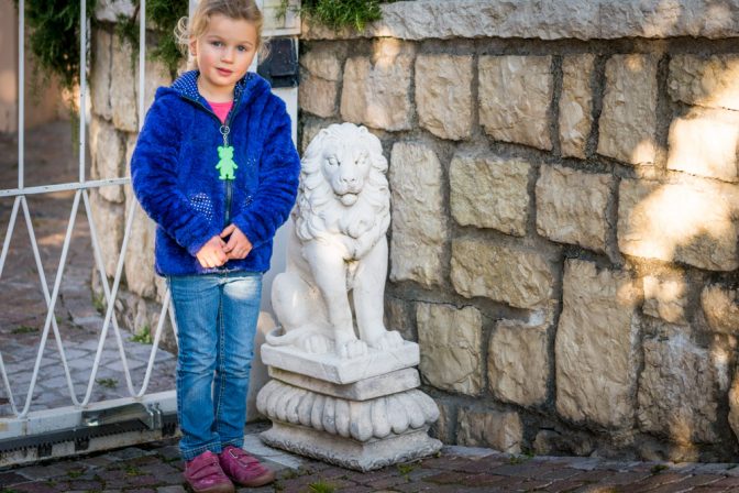 Lisa mit Löwe vor dem Tor des Parkhotels Kalterer See