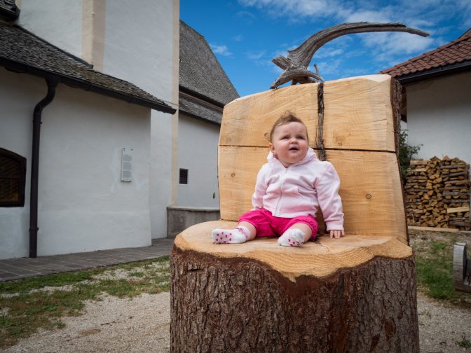 Kleine Anna auf großen Holzstuhl