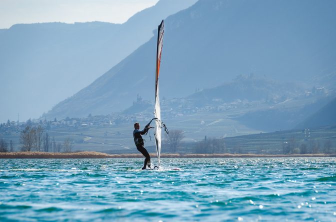 Surfer auf dem Kalterer See - im Hintergrund Tramin