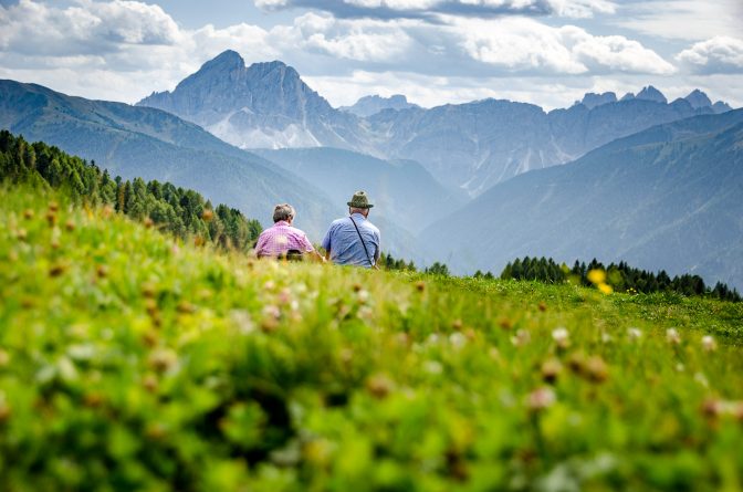 Seniorenpärchen auf der Alm blickt zum Peitlerkofel