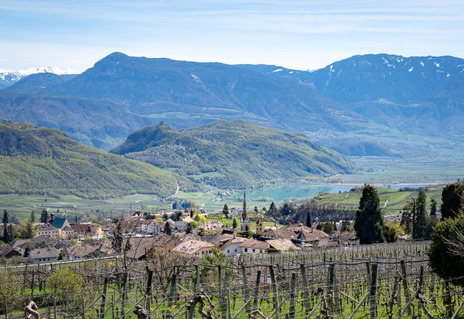 Blick über den Kirchturm von Mitterdorf hinunter zum Kalterer See