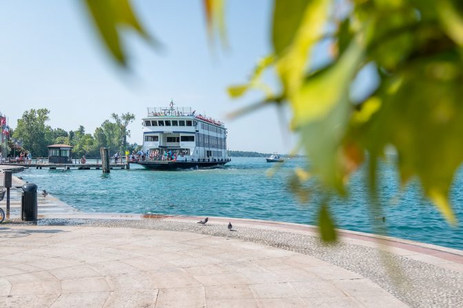 Eine Gardasee-Fähre legt am Pier wenige Meter vom historischen Fischerhafen an.