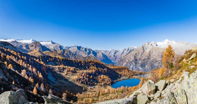 Blick von der Bocchetta dell'Acqua Fredda auf die Gipfel zwischen Carè Alto und Cima Presanella, im Tal auf die Alm Malga Garzonè und die beiden Seen Lago di Garzonè und Lago di San Guliano