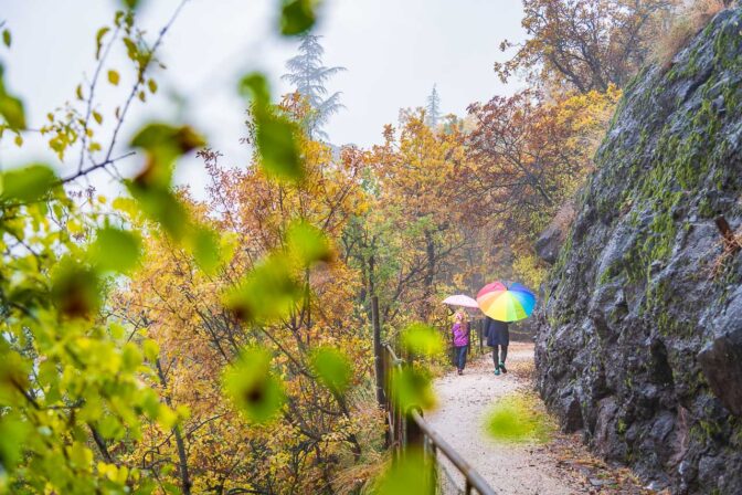 Mit dem Regenschirm auf der Oswald-Promenade