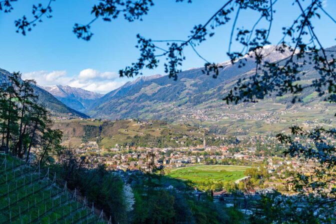 Blick zurück auf die Kurstadt Meran mit dem Pferderennplatz und dahinter dem Eingang zum Passeiertal