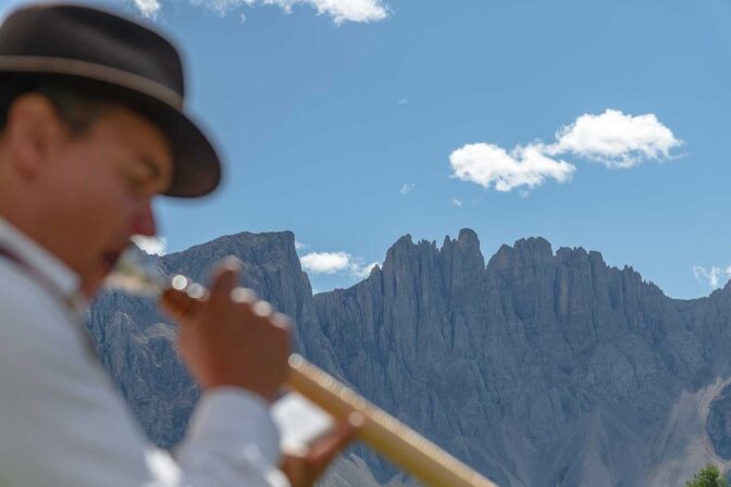 Alphornbläser vor Dolomiten-Kulisse (Latemar)