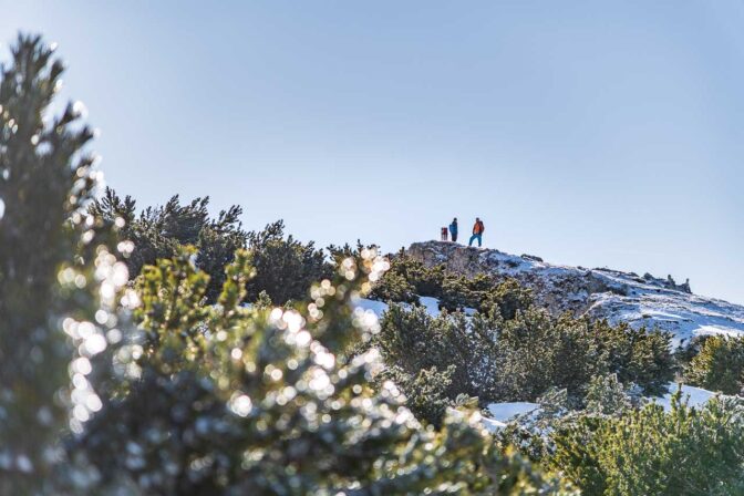 Winterwanderer auf dem Gipfel des Traminer Hausberges, dem Roen