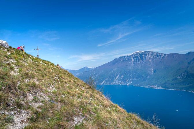 Das Gipfelkreuz auf dem Monte Bestone mit dem Gardasee dahinter